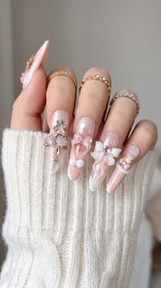 Long stiletto pink and white press-on nails worn on hand
