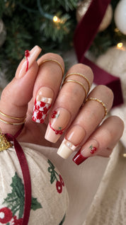 Cherry Ribbon Kiss red and nude pink press-on nails worn on hand, featuring long coffin nails with 3D cherries, pearl ribbon bows, plaid French tips, and sweet coquette nail art.