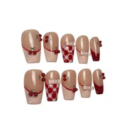 Cherry Ribbon Kiss long coffin press-on nail set featuring cherry red and nude pink French tips, 3D cherry charms, pearl bows, red-and-white plaid patterns, and glossy finishes.