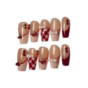 Cherry Ribbon Kiss long coffin press-on nail set featuring cherry red and nude pink French tips, 3D cherry charms, pearl bows, red-and-white plaid patterns, and glossy finishes.
