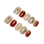 Cocoa & Twinkle short oval press-on nail set featuring metallic cocoa brown, creamy ivory, red polka dots, a sparkling Christmas tree design, and iridescent silver glitter accents.