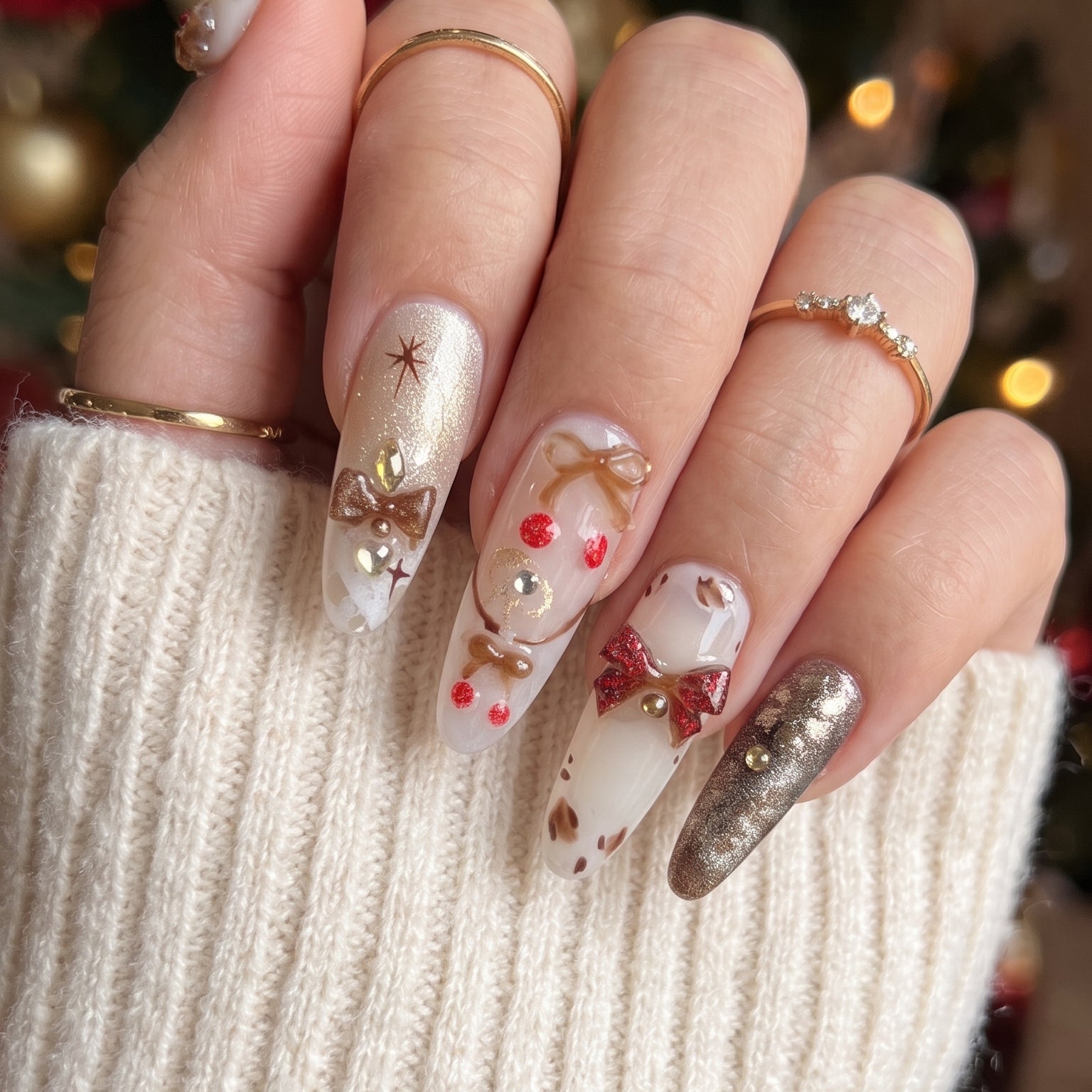 Gingerbread Wishes Christmas press-on nails worn on hand, featuring long almond nails with gingerbread designs, gold glitter, 3D bows, red accents and cozy winter nail art.