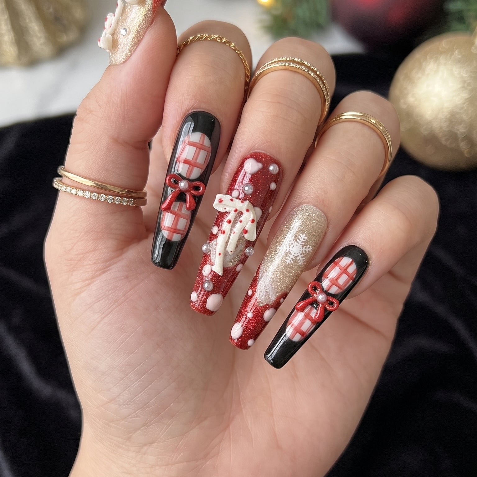 Midnight Candy Bows Christmas press-on nails worn on hand, featuring long coffin nails with red and black plaid designs, 3D candy canes, festive bows and sparkling snowflakes.