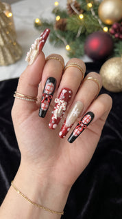Midnight Candy Bows Christmas press-on nails worn on hand, featuring long coffin nails with red and black plaid designs, 3D candy canes, festive bows and sparkling snowflakes.
