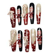 Midnight Candy Bows long coffin Christmas press-on nail set featuring glossy black, glittery red, 3D candy cane charms, red ribbon bows, plaid patterns and snowflake accents.