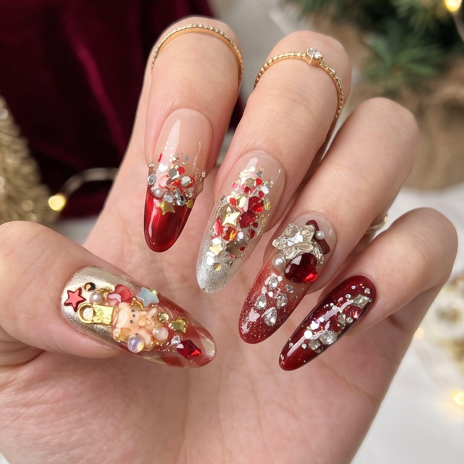 Ruby Teddy Treasures luxury press-on nails worn on hand, featuring long coffin nails with ruby red glitter, gold accents, 3D teddy bears, jeweled bows and pearl embellishments.